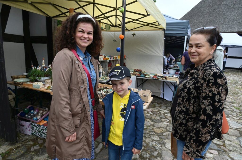 Dwie kobiety i chłopiec pozujący do zdjęcia przy stoisku z rękodziełem podczas jarmarku (kliknięcie powiększy zdjęcie).