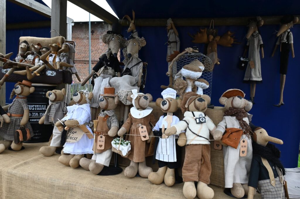 Ręcznie szyte lalki i maskotki ubrane w stroje stylizowane na dawne zawody na stoisku jarmarcznym (kliknięcie powiększy zdjęcie).