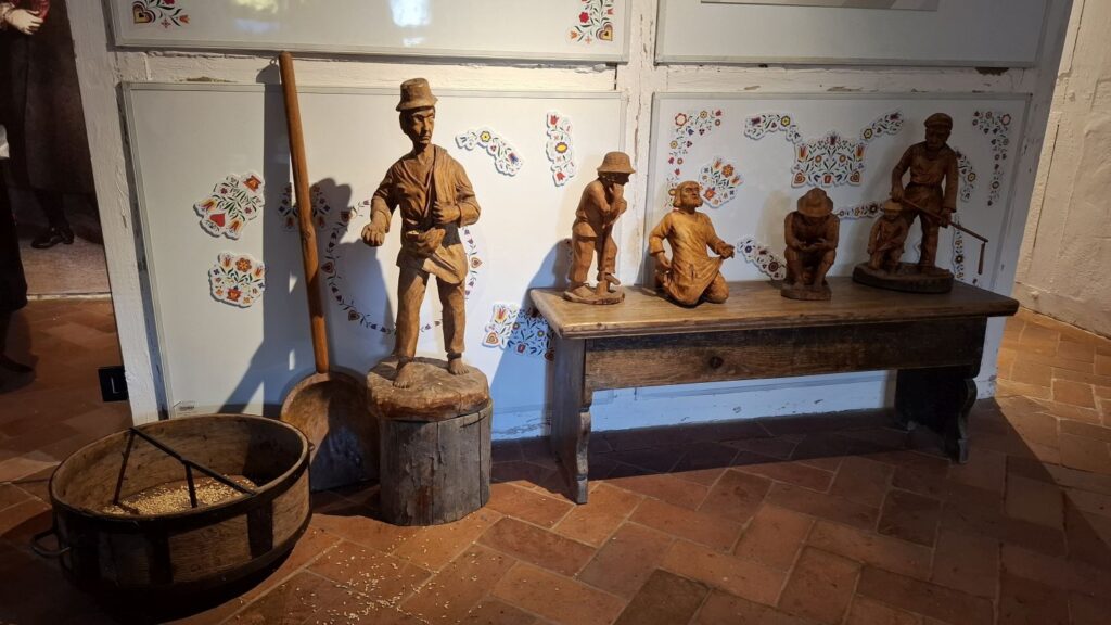 Wnętrze chałupy z wystawą drewnianych rzeźb przedstawiających postacie chłopów przy codziennych zajęciach (kliknięcie powiększy zdjęcie).