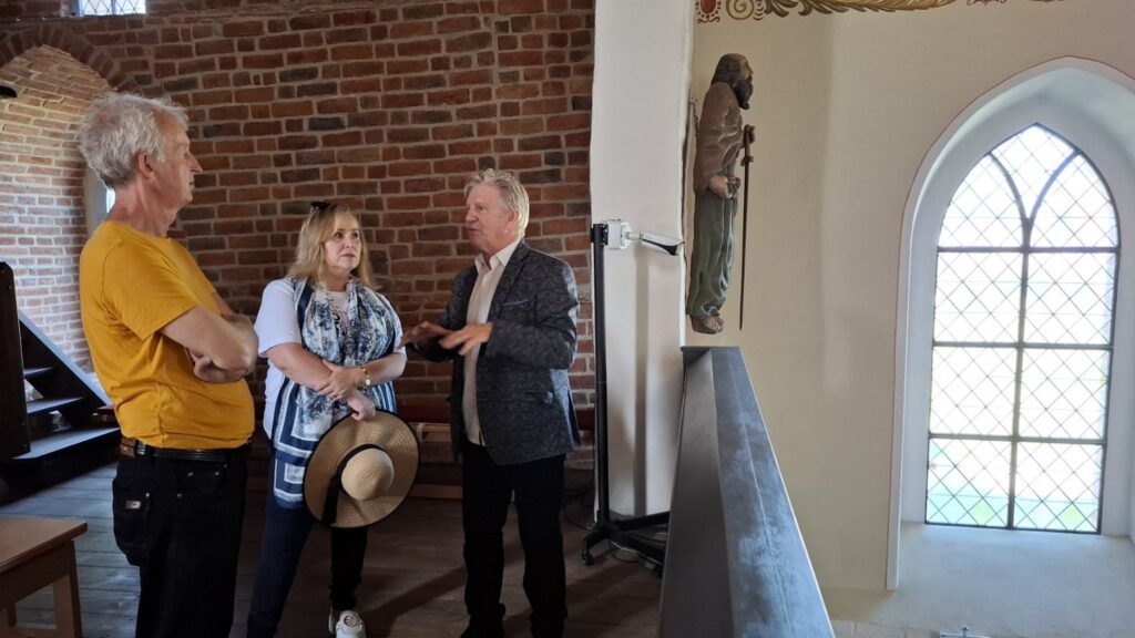 Osoby rozmawiające we wnętrzu zabytkowego kościoła (kliknięcie powiększy zdjęcie)