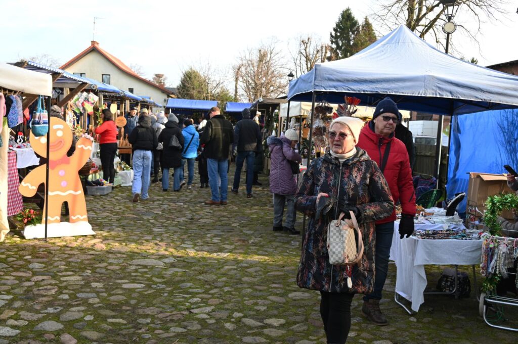 Widok ogólny Jarmarku Jamneńskiego – stragany, namioty handlowe i spacerujący odwiedzający na brukowanym placu (kliknięcie powiększy zdjęcie).