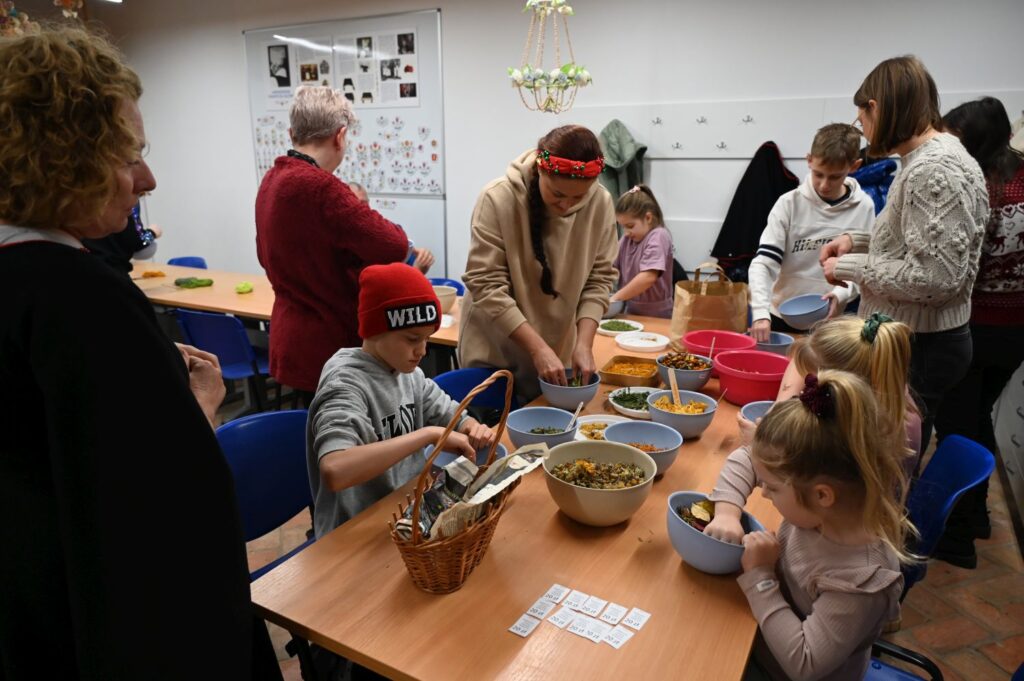 Warsztaty dla dzieci przy stole z materiałami plastycznymi podczas wydarzeń towarzyszących jarmarkowi jamneńskiemu (kliknięcie powiększy zdjęcie).